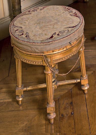 null A moulded, carved and gilded beechwood piano stool; circular shape with heart-shaped...