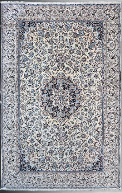 null Naïn carpet with central floral medallion and arabesques on a cream field.
Iran,...