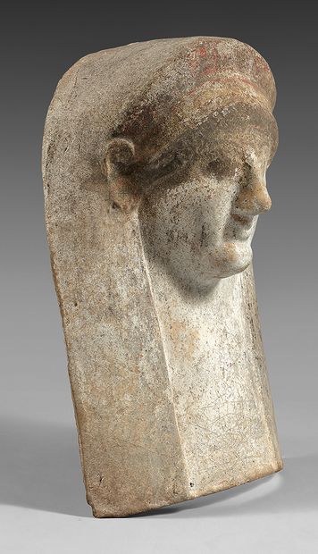Archaic female protome. She is wearing a...