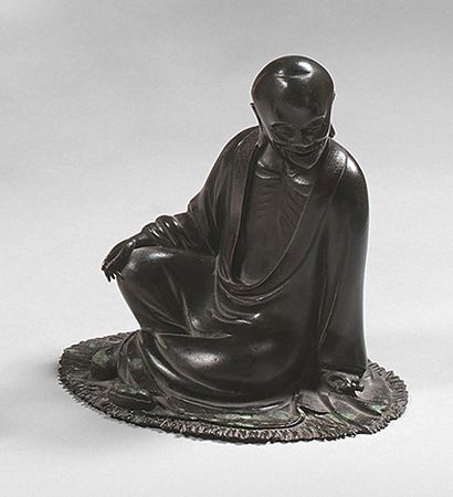 CHINE Statuette de Luohan en bronze à patine brune, assis sur une natte, une cloche...