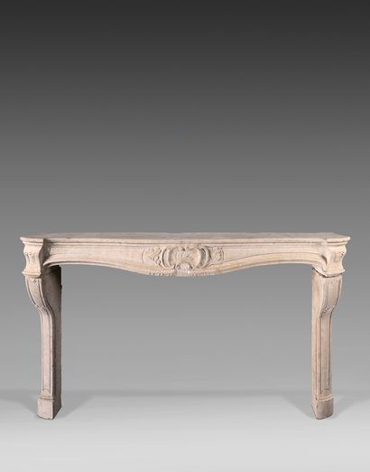 null Limestone mantel; the apron centered with a rocaille cartouche framed with laurel...
