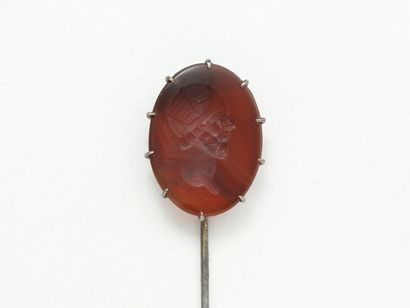 null A metal tie pin set with a ribboned agate intaglio showing a man with a helmet,...