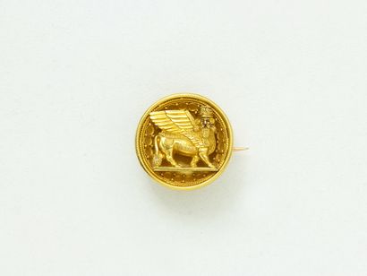 null 
Small 
brooch in gold 750 thousandths, of round form representing 
a winged...