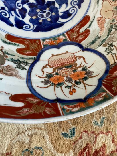 null Japon, un grand plat en porcelaine dans la palette imari à décor de chevaux....