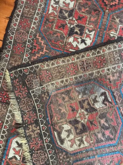  Lot of three very worn carpets including a gallery, a cut fragment and a blue Persian...