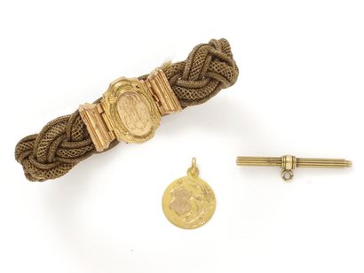 null Lot in gold 750 thousandths, composed of a religious medal, a watch key, and...
