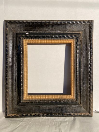 Frame in molded and blackened wood and gilded...