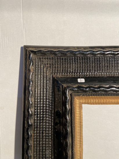  Frame in molded and blackened wood and gilded foliage with guilloche decoration...