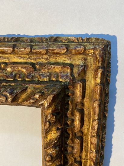 null Cadre en bois sculpté et anciennement doré à profil renversé à décor de frises...