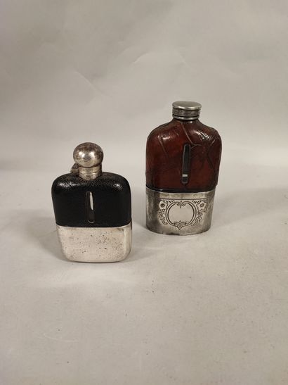 null Deux flasques en verre recouvert cuir, gobelets et bouchons en métal argenté....