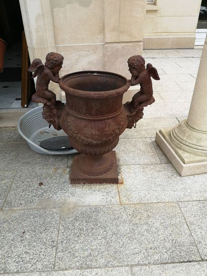 null Paire de vases en fonte à anses formé de Putti assis sur des muffles de lions,...