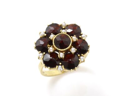 null Ring flower out of gold 750 thousandths, dressed with round facetted garnets,...