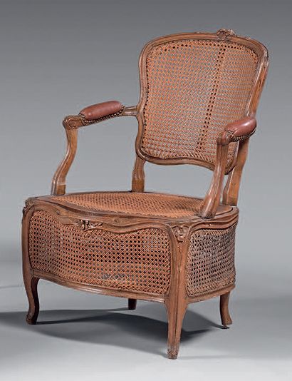 null Fauteuil de commodité en hêtre mouluré et sculpté à décor de fleurettes et feuillages...