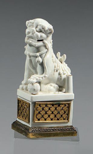 CHINE, Dehua Large "Chinese white" Noh dog sitting on a quadrangular base holding...