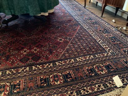 
Grand tapis Perse fond rouge, décor de motifs...