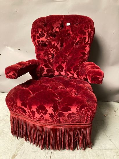 Upholstered armchair with red velvet upholstery...