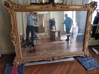 Large mirror in gilded wood and carved with...