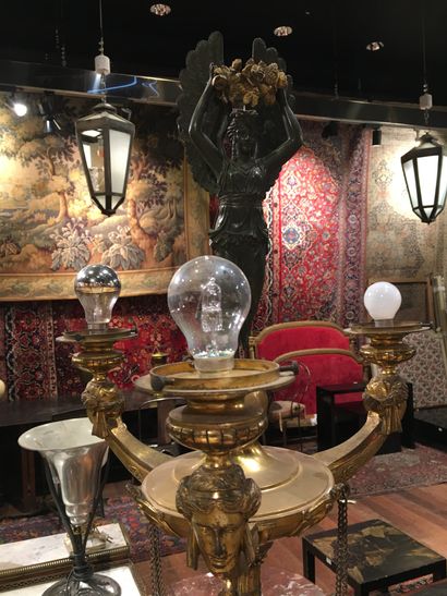 null Lampadaire tripode en métal patiné et edoré, à décor de têtes à l'Antique drapées;...