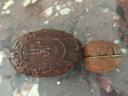 null Two carved wooden boxes, one in the shape of a walnut shell, the other oval...