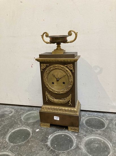 null Clock in gilded metal decorated with garlands of flowers and a cup with handles...