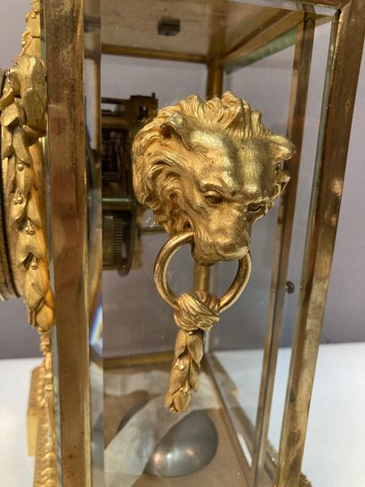 null Pendule de table en bronze doré et caisse en verre, à décor de muffles de lion...