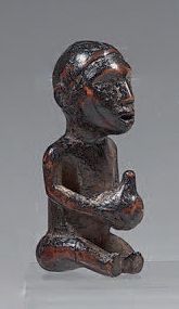  Petit fétiche Kongo (Congo) figurant un personnage assis tenant une calebasse entre...