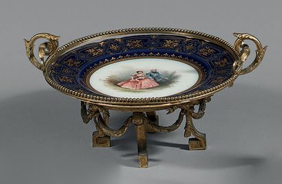 PARIS Assiette circulaire en porcelaine à décor central d'une scène galante traitée...