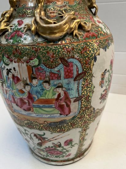 null Canton, vase en porcelaine de forme balustre à décor polychrome de personnages...