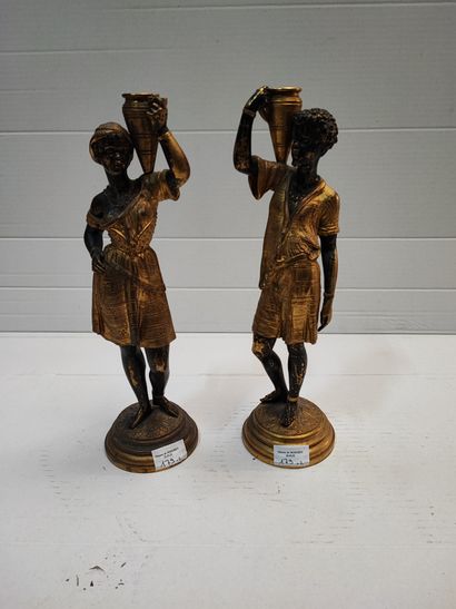 null Paire de statuettes en bronze patiné et doré représentant un couple de nubiens...