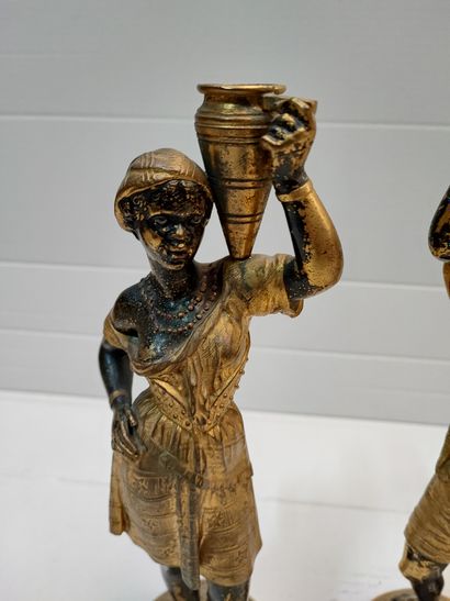 null Paire de statuettes en bronze patiné et doré représentant un couple de nubiens...