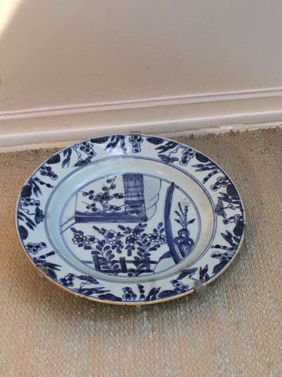 null DELFT. Round earthenware dish, blue camaïeu decoration in the center of a flowery...