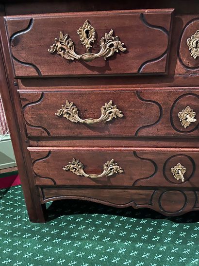 null A molded fruitwood chest of drawers, opening with four drawers on three rows....