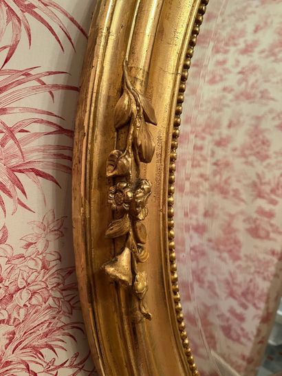 null Oval bevelled mirror, wood and gilded stucco frame, acanthus leaves and flowers,...