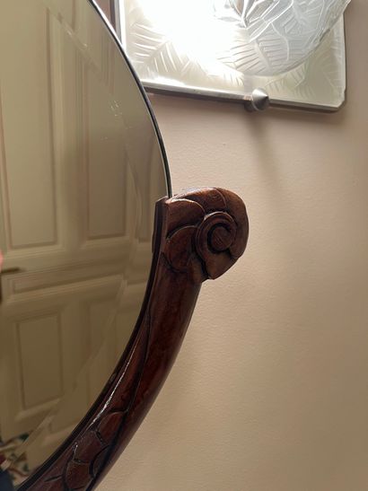 null Oval beveled mirror, wood frame carved with stylized flower buds. Art Deco....