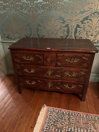 A molded wood chest of drawers, opening with...