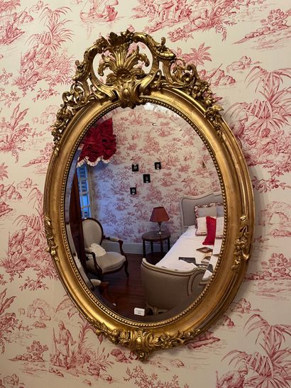 Oval bevelled mirror, wood and gilded stucco...