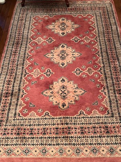 null Tapis en laine, fond vieux rose, au centre trois losanges.
Kakachi, Pakistan...