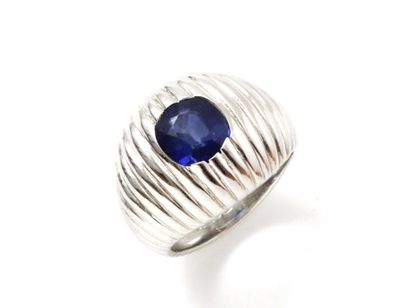 null Fully gadrooned 750 thousandths white gold ring set with an oval faceted sapphire...