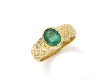 null Wedding band ring in 750 thousandths gold, set with an oval faceted emerald...