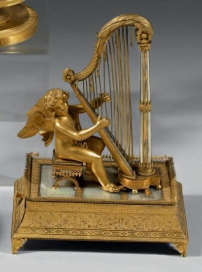  Baguier en bronze, laiton et nacre, représentant un amour jouant de la harpe. Il...