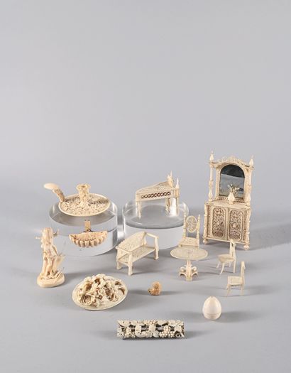 null Lot of fourteen finely carved or beaded ivory curios, including a candlestick...