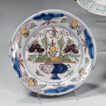 DELFT Assiette ronde décorée en polychromie d'un panier fleuri Fin du XVIIIème siècle...