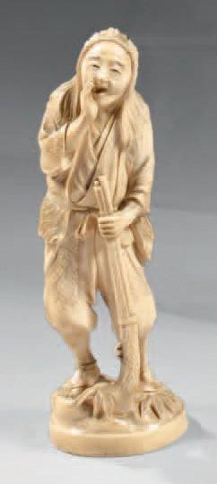 JAPON Okimono en ivoire à patine jaune, chasseur debout avec son teppo et imitant...