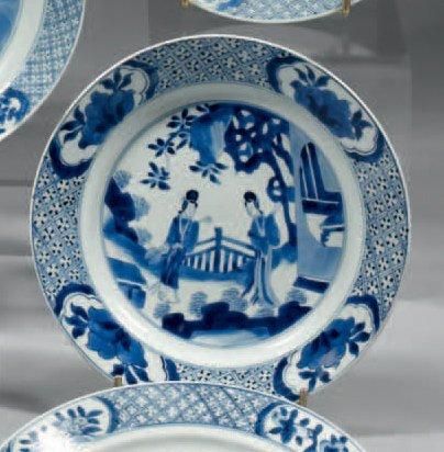 CHINE Assiette circulaire décorée en bleu sous couverte d'une scène animée deux femmes...