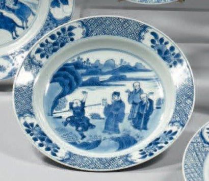 CHINE Assiette circulaire décorée en bleu sous couverte d'une scène animée de quatre...
