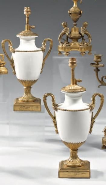 null Paire de vases en porcelaine blanche, de forme ovoïde, à monture de bronze ciselé...
