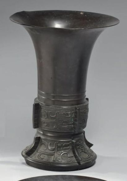 CHINE - XIXème siècle Vase de forme "gu" en bronze à patine brune à décor ciselé...