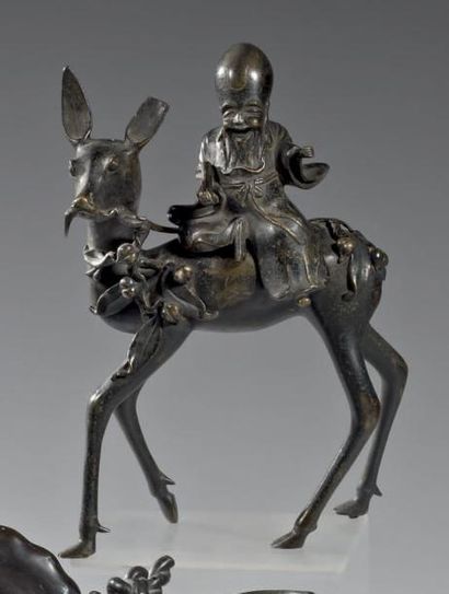 CHINE - XIXème siècle Groupe en bronze à patine brune, Laozi assis sur son cerf....