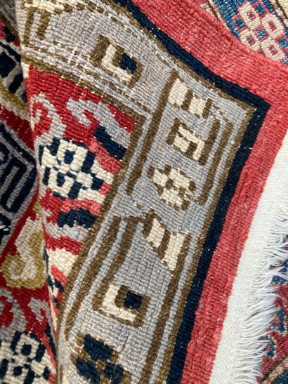 null Set of four woollen carpets, the largest with geometric decoration on a red...