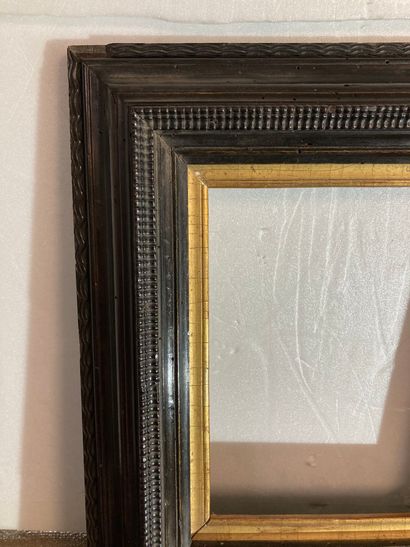 null A blackened molded wood frame with inverted profile and guilloché decoration,...